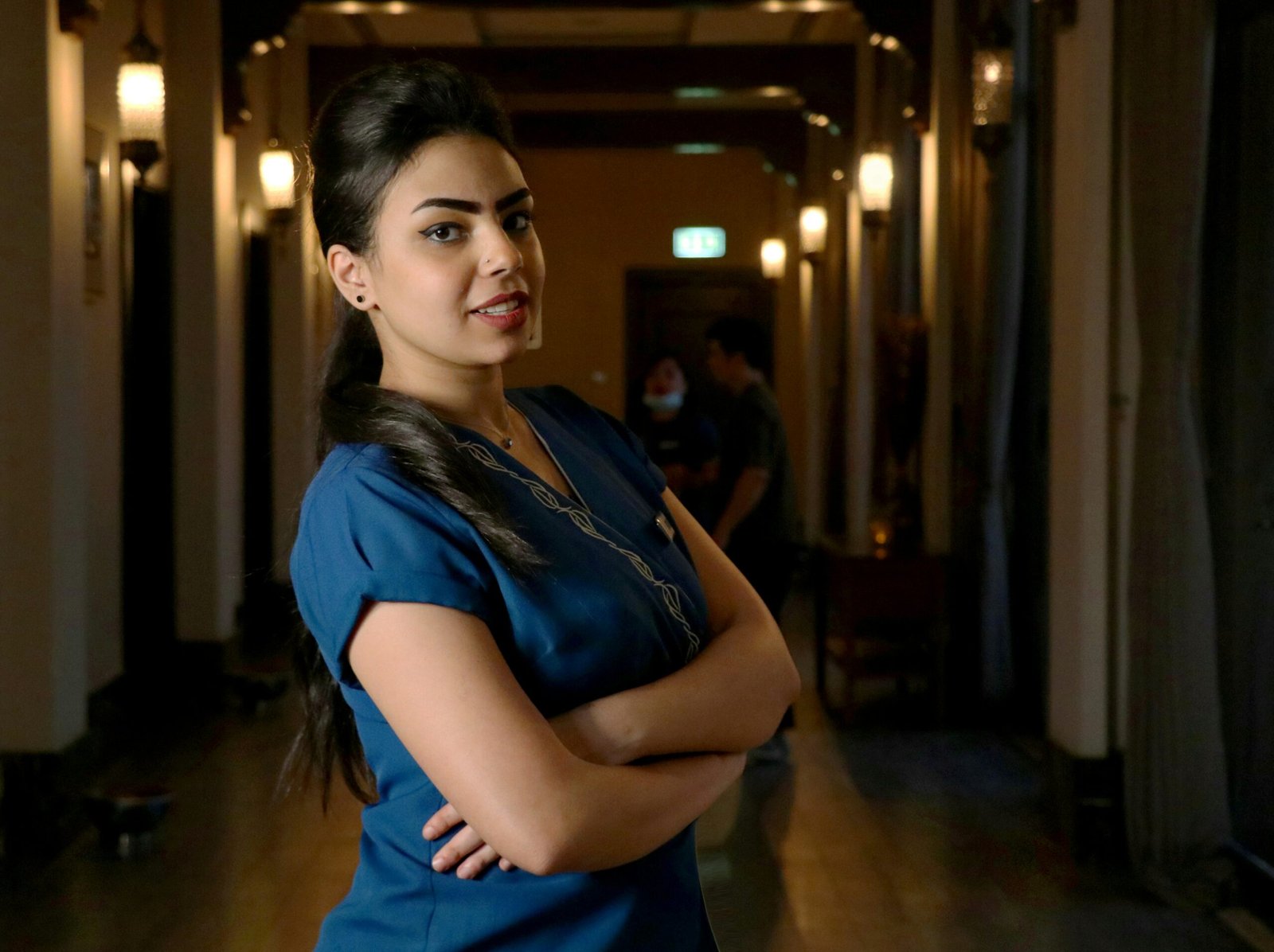 woman in blue shirt standing on hallway